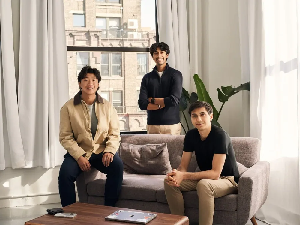 Three people photographed together in a bright room.