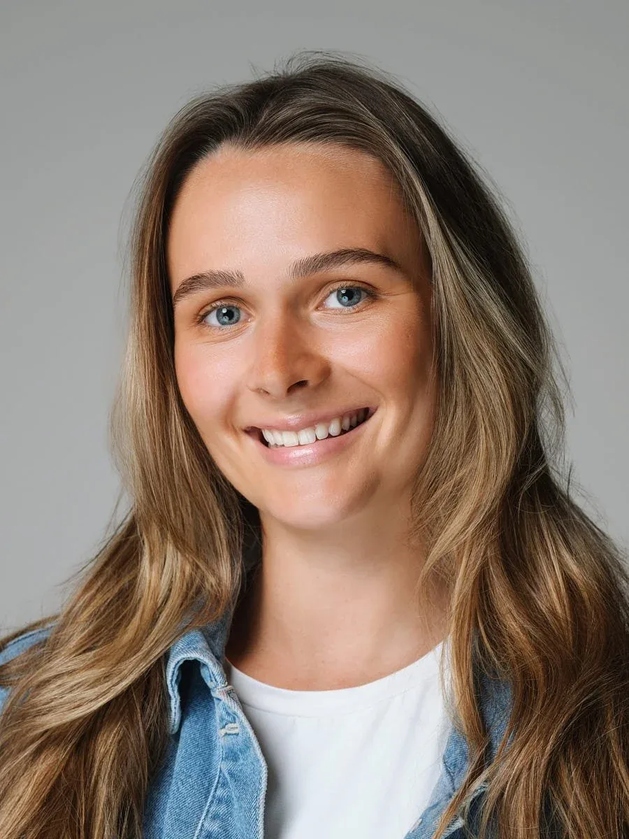 Woman in a denim jacket against a grey background.